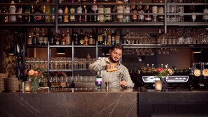A bar with shelves of liquor bottles and glasses. - Van Der Valk Hotel Stein - Urmond (Urmond)