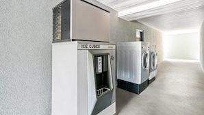 A laundry facility with an ice cube dispenser and a washing machine. - Americas Best Value Inn Rome (Rome)