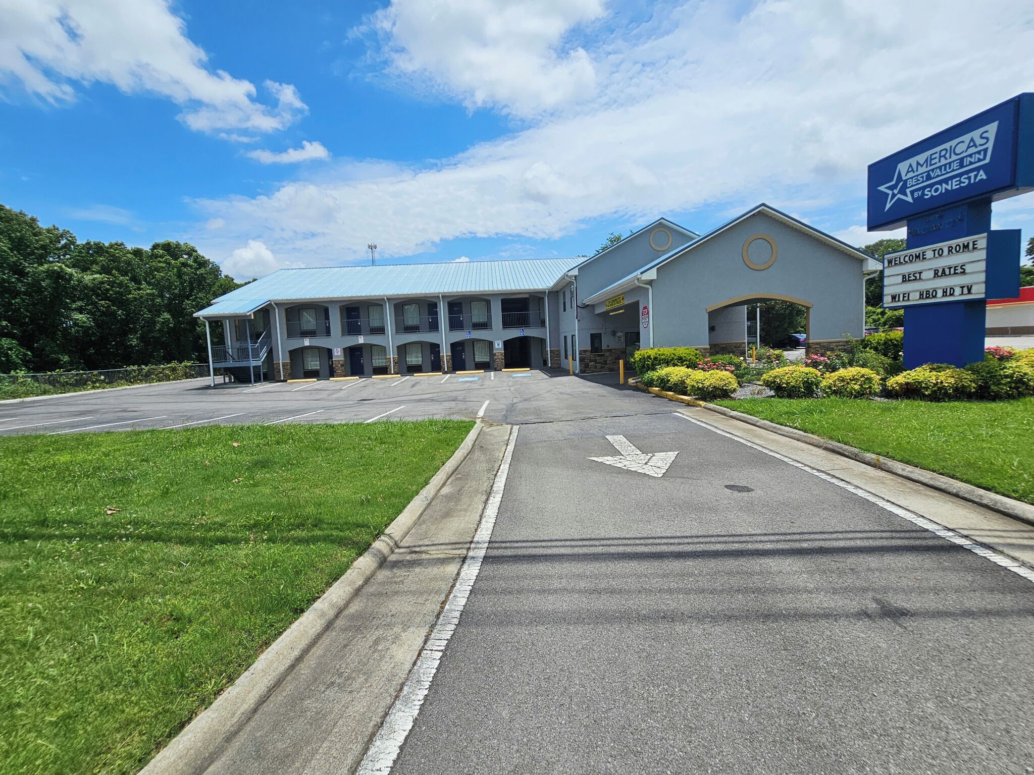 Un hotel con tejado azul, varios balcones y un cartel que indica que es Americas Best Value Inn by Sonesta.