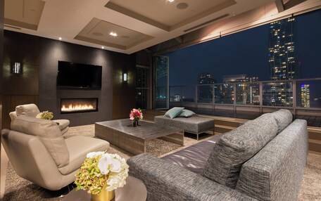 A modern living room with a fireplace, comfortable seating, and a large TV.