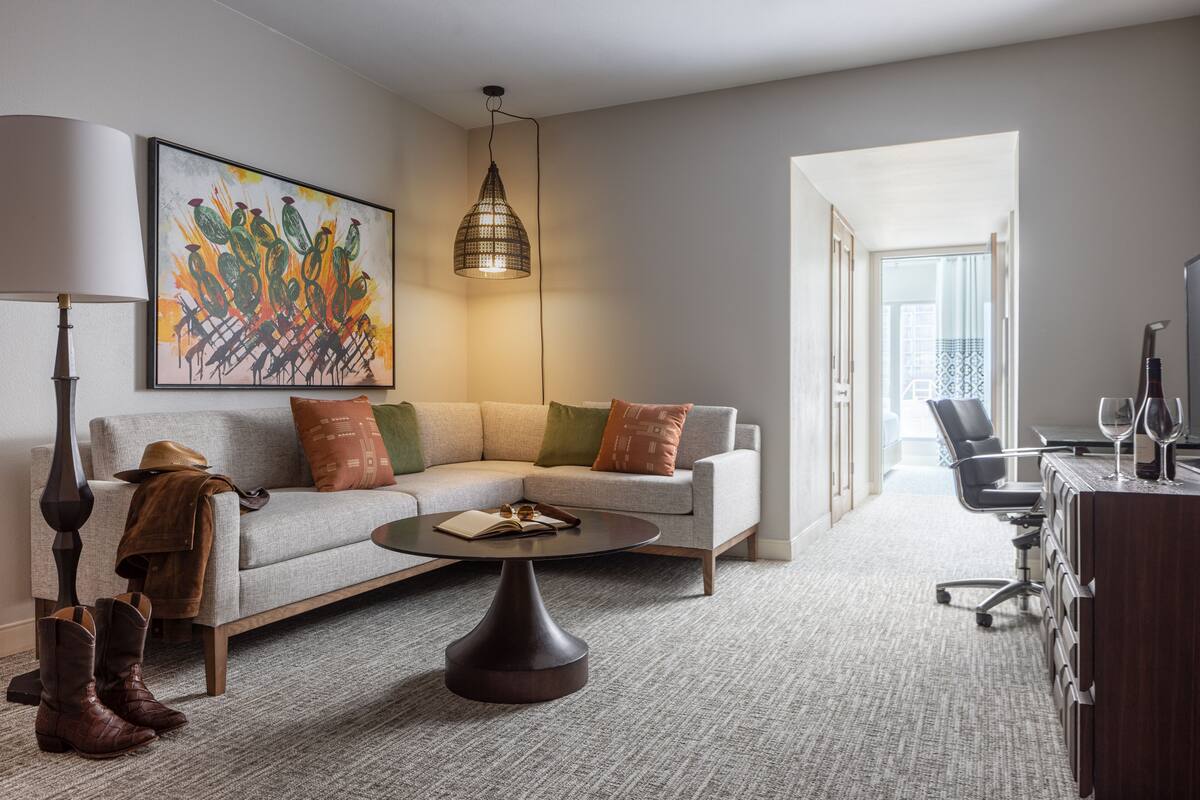 Un salon moderne avec un canapé, une table basse et un tableau accroché au mur.