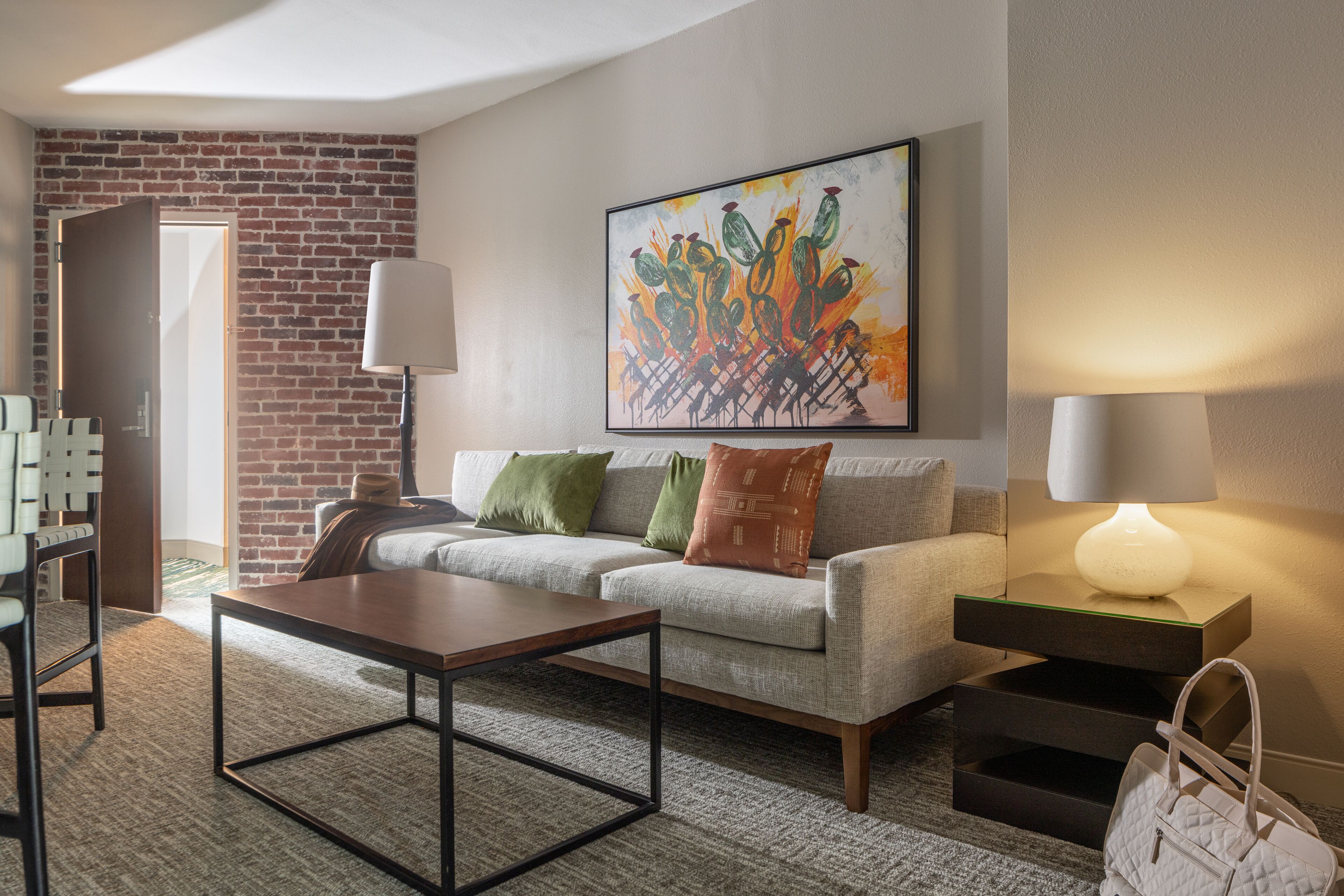 A modern living room with a sofa, coffee table, and artwork on the wall.