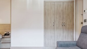A room with a high wooden ceiling, a grey sofa, and a wardrobe. - Hotel Venta Etxalar (Etxalar)