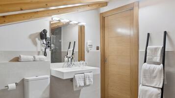 Un baño moderno con inodoro, lavamanos, espejo y toallero.