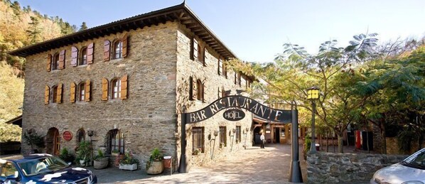 A stone building with a sign reading "BAR RESTAURANT HOTEL".
