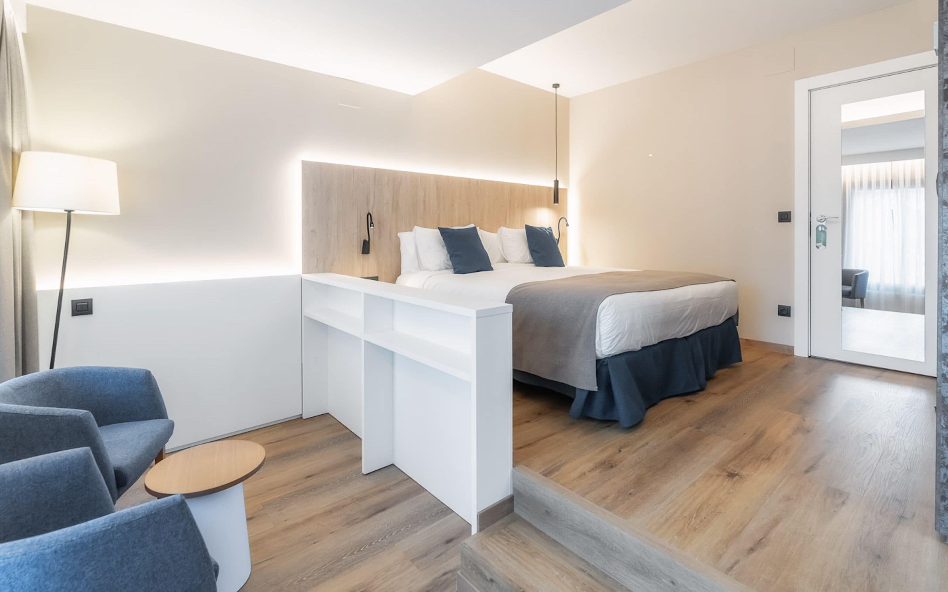 A modern bedroom with a bed, a desk, and a chair.