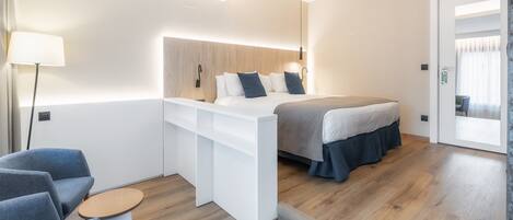 A modern bedroom with a bed, a desk, and a chair.