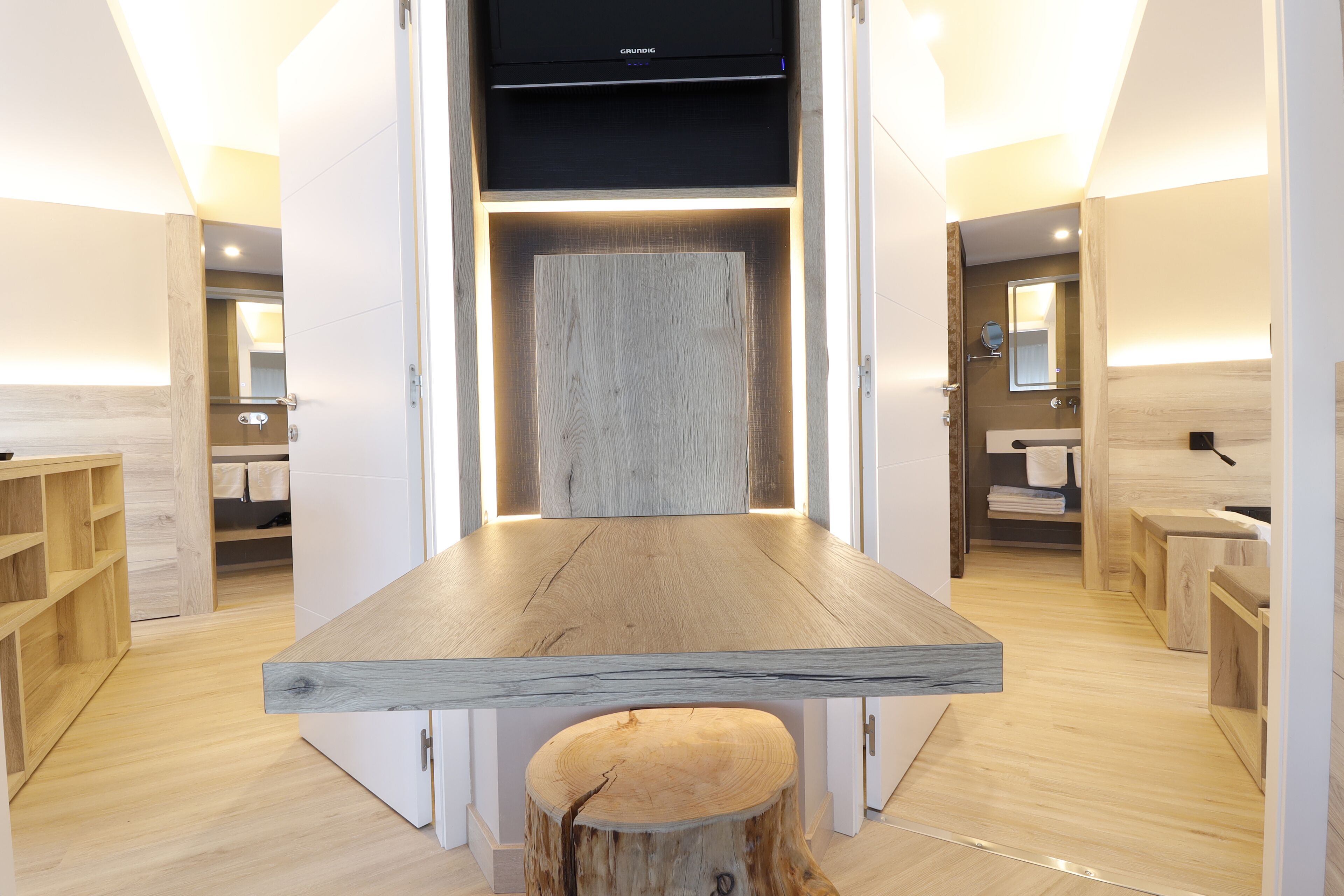 Un baño moderno con tocador de madera, un lavabo y un espejo.