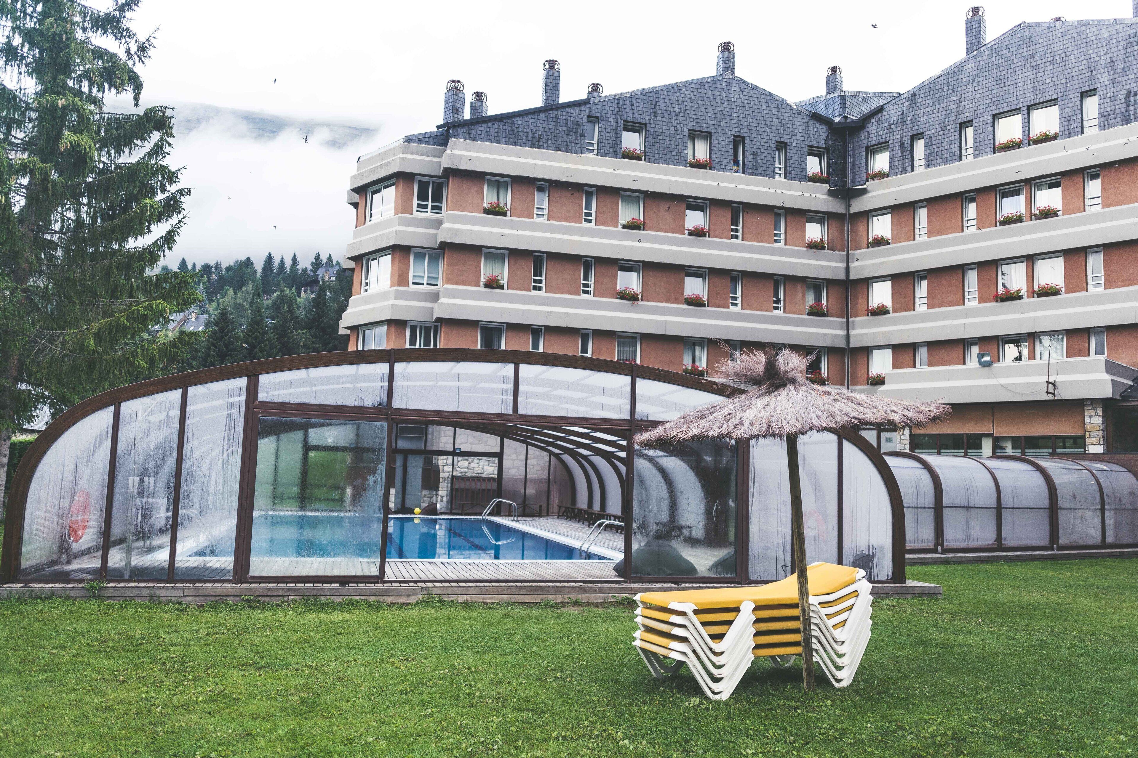 A modern building with a swimming pool and a covered outdoor seating area.