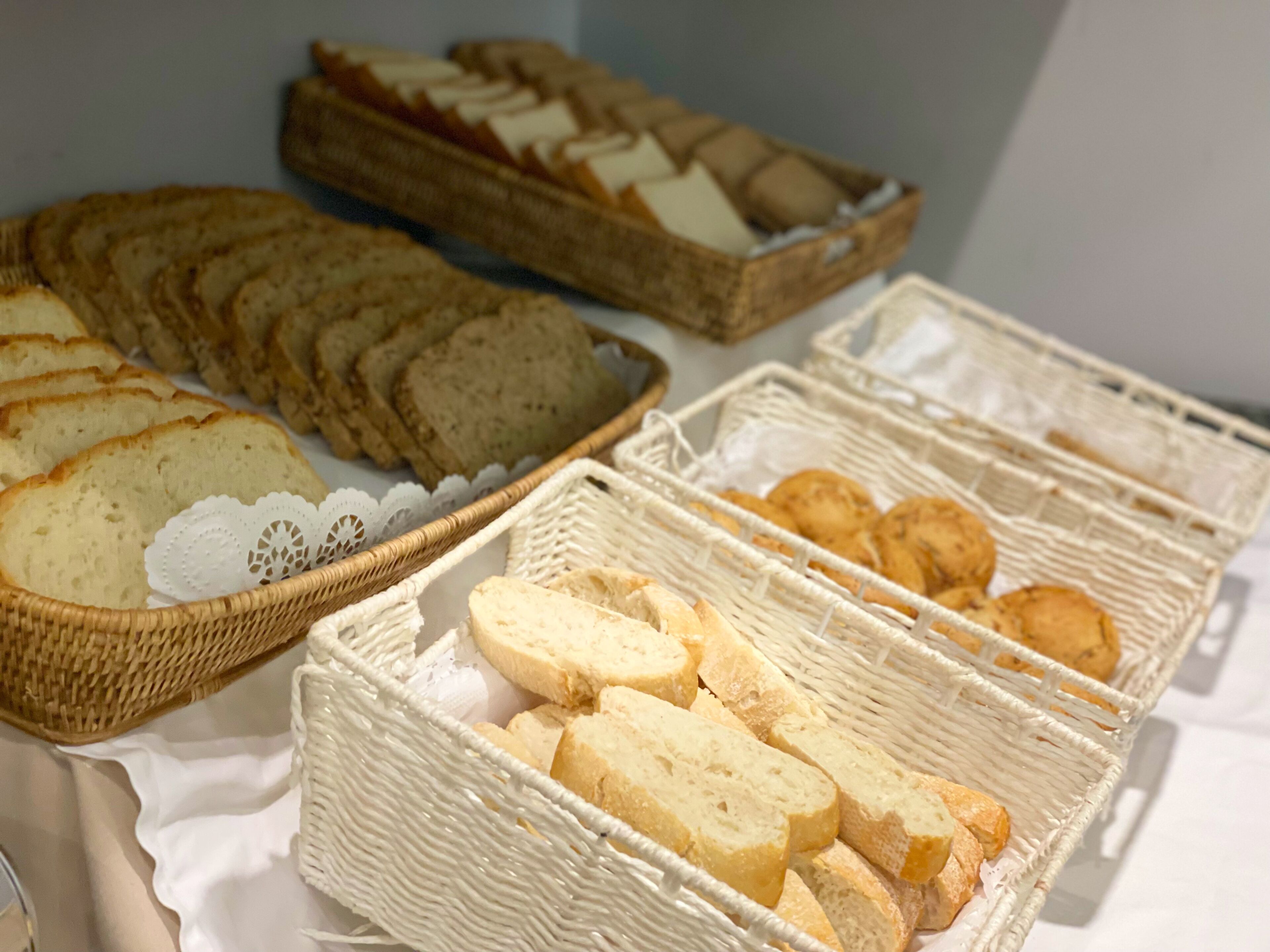 Uma mesa com pães e doces variados em cestos de vime.