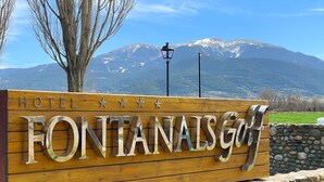 Een houten bord met de naam 'FONTANAISGOLF' en 'HOTEL', dat een golfora resort aangeeft.