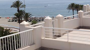Balcón de hotel frente al mar, con vista a la playa y al océano.