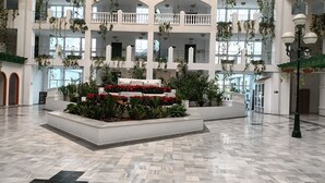 A spacious atrium with a central garden, multiple balconies, and a high ceiling.