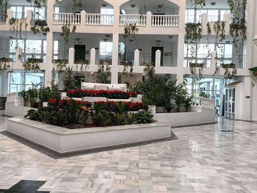 Un atrio amplio con jardín central, varios balcones y un techo alto.