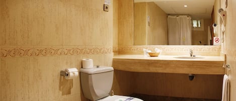 Un bagno con il water, lavandino e specchio.