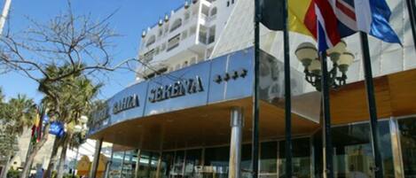 A hotel with a modern facade, large glass windows, and a sign that reads "Hotel Bahia".
