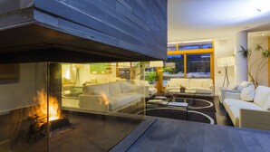 A modern living room with a fireplace, white sofas, and a coffee table. - Tierra De Biescas Hotel (Biescas)