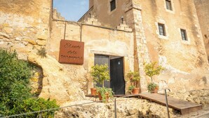 A stone building with a sign reading "El pati de los tascas". - Gran Claustre Boutique Hotel & SPA (Altafulla)