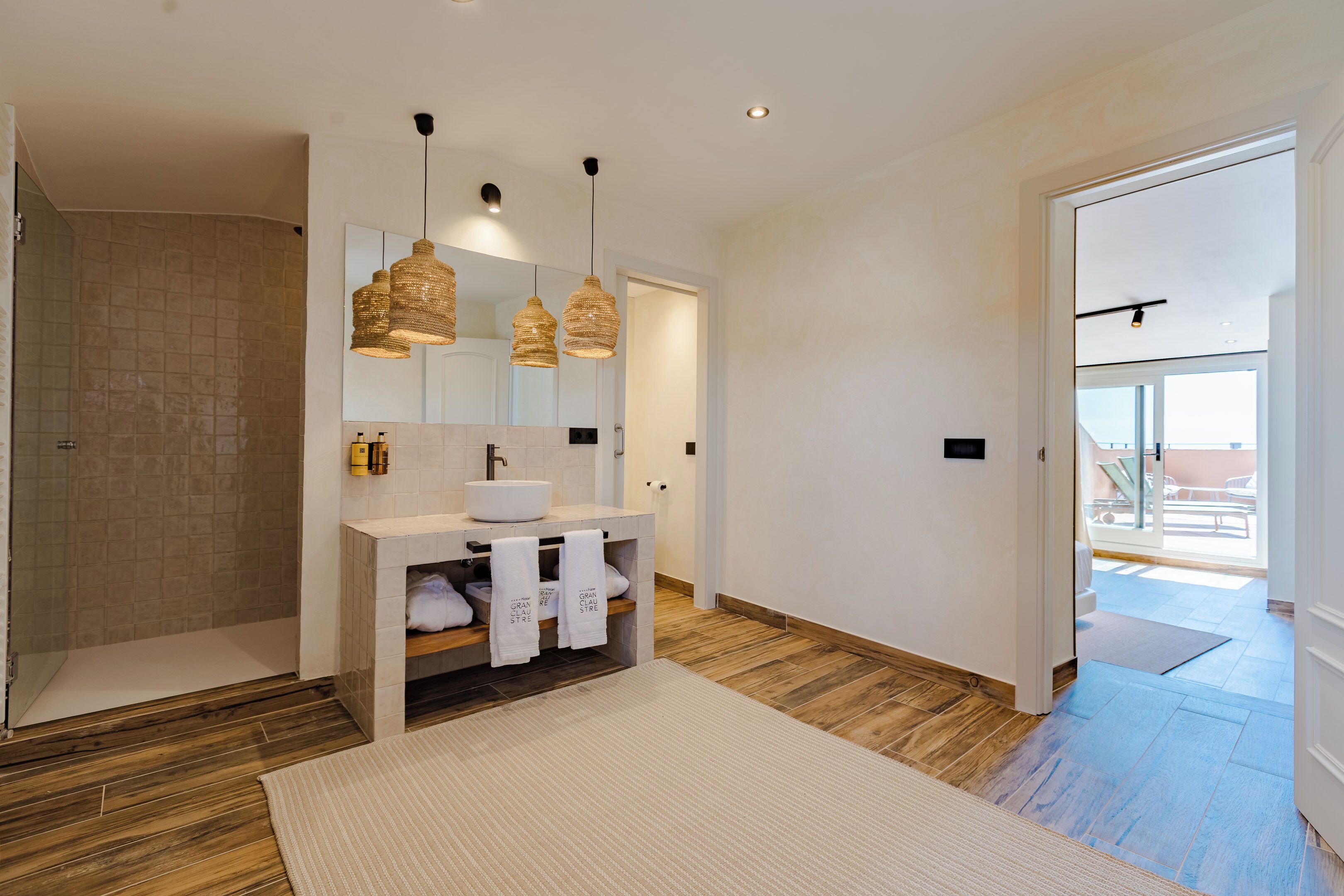 Un bany modern amb un mirall gran, un lavabo blanc i una zona de dutxa.