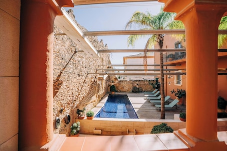 Una piscina al aire libre, sillones reclinables de piscina