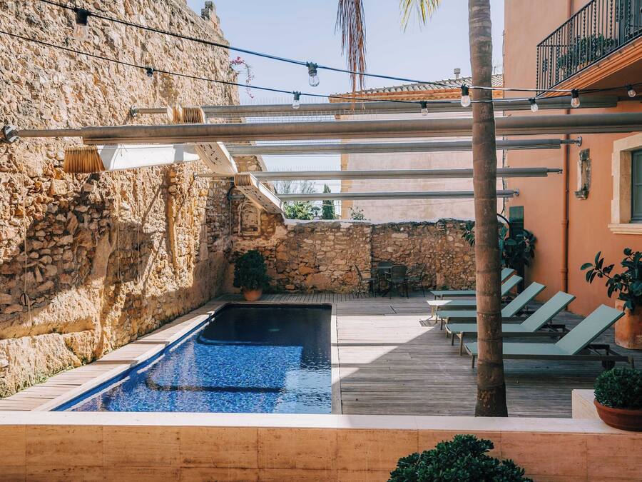 Una piscina al aire libre, sillones reclinables de piscina