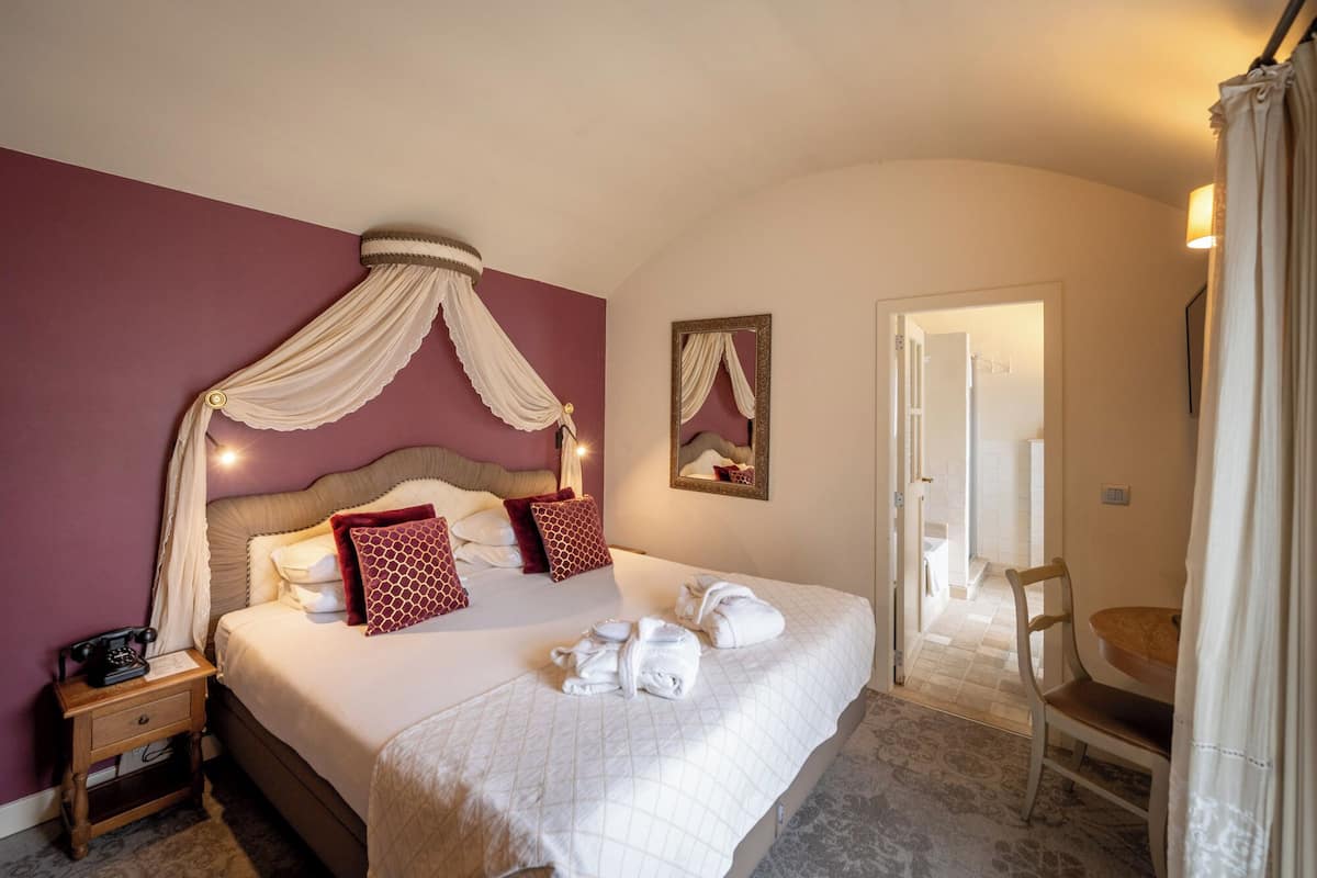 Un dormitorio ordenado con cama, mesita de noche y una silla.