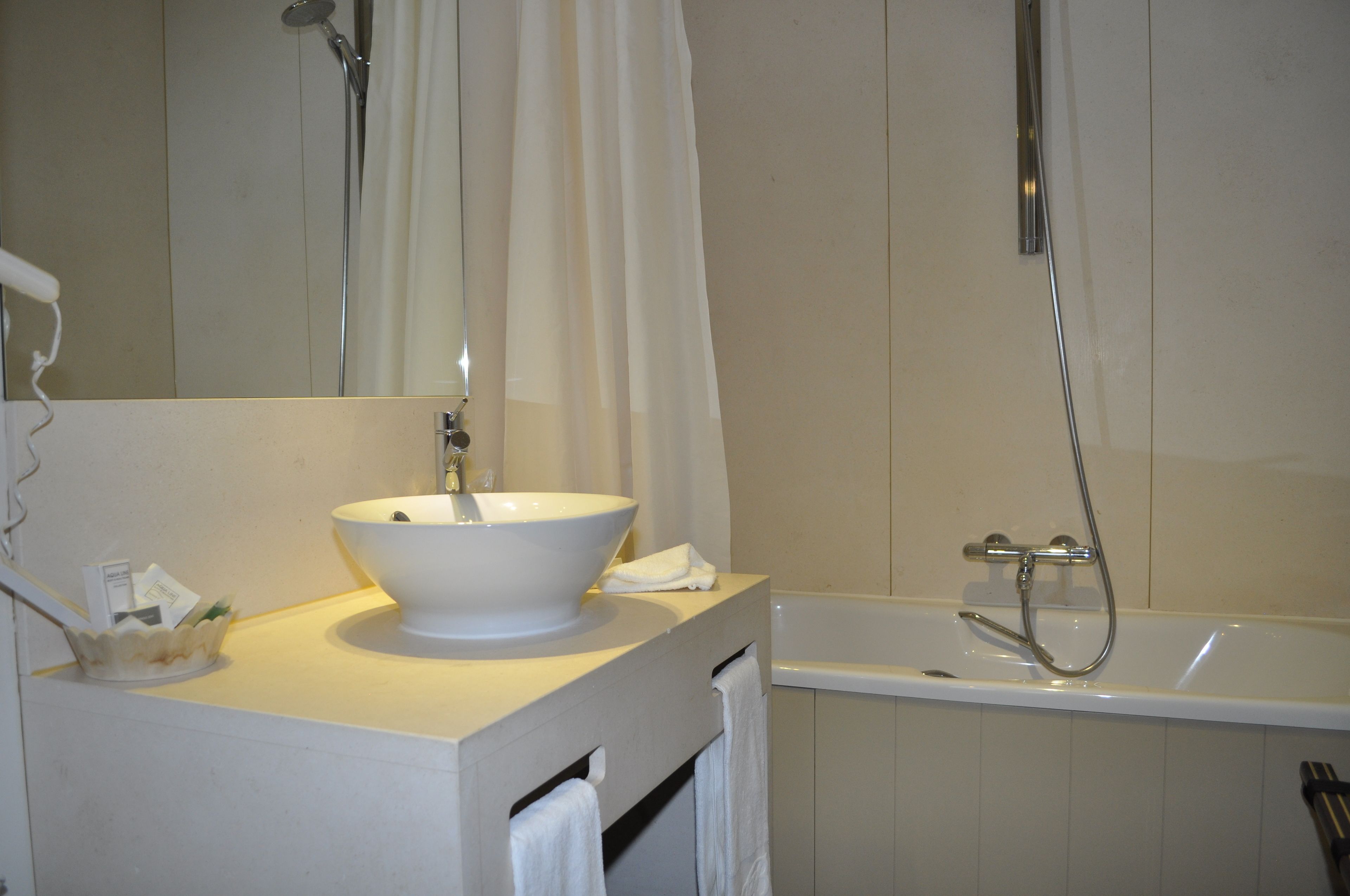 Ein Badezimmer mit Waschbecken, Spiegel, Dusche und Badewanne.