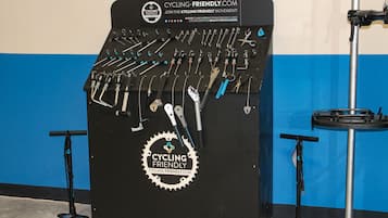 A wall-mounted rack with various cycling tools and a logo for Cycling Friendly.