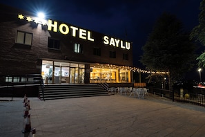A hotel with a prominent sign, outdoor seating, and a staircase leading to the entrance. - Hotel Saylu (Granada)