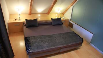 Un dormitorio pequeño y acogedor con una cama individual, dos mesitas de noche y una mesilla.