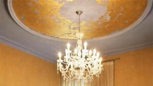 Ein Hotelzimmer mit einem großen Bett, einer Kandelaber, einem Schreibtisch und einem Sessel.