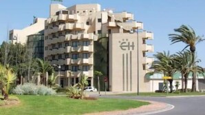 A modern hotel with a unique architectural design, featuring multiple balconies and a central entrance. - Ejido Hotel (El Ejido)