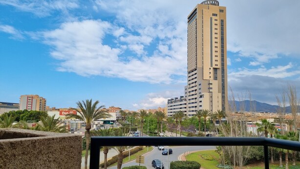 A high-rise building with a modern design, surrounded by palm trees and a clear sky. - Ejido Hotel (El Ejido)