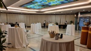 A spacious indoor venue with multiple round tables covered in white tablecloths, arranged in rows. - Ejido Hotel (El Ejido)