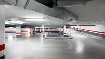 Een meerlaags parkeergarage met betonnen pilaren, rode en witte strepen en een schone, goed verlichte omgeving.