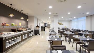 En modern hotellrestaurang med en buffé, flera bord och en ren och väl upplyst miljö.