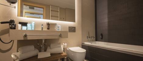 Un baño moderno con inodoro, lavamanos y bañera.