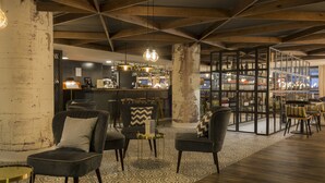 Zona de bar con asientos, barra y exhibición de botellas.