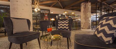 Un área de lounge moderna con asientos cómodos, una barra al fondo y un suelo con diseño.