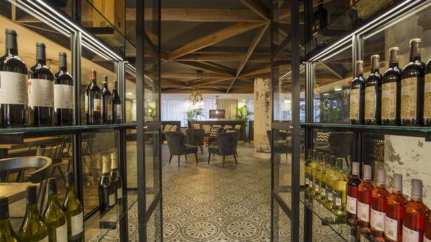 Una bodega con estantes de vidrio que exhiben diversas botellas.