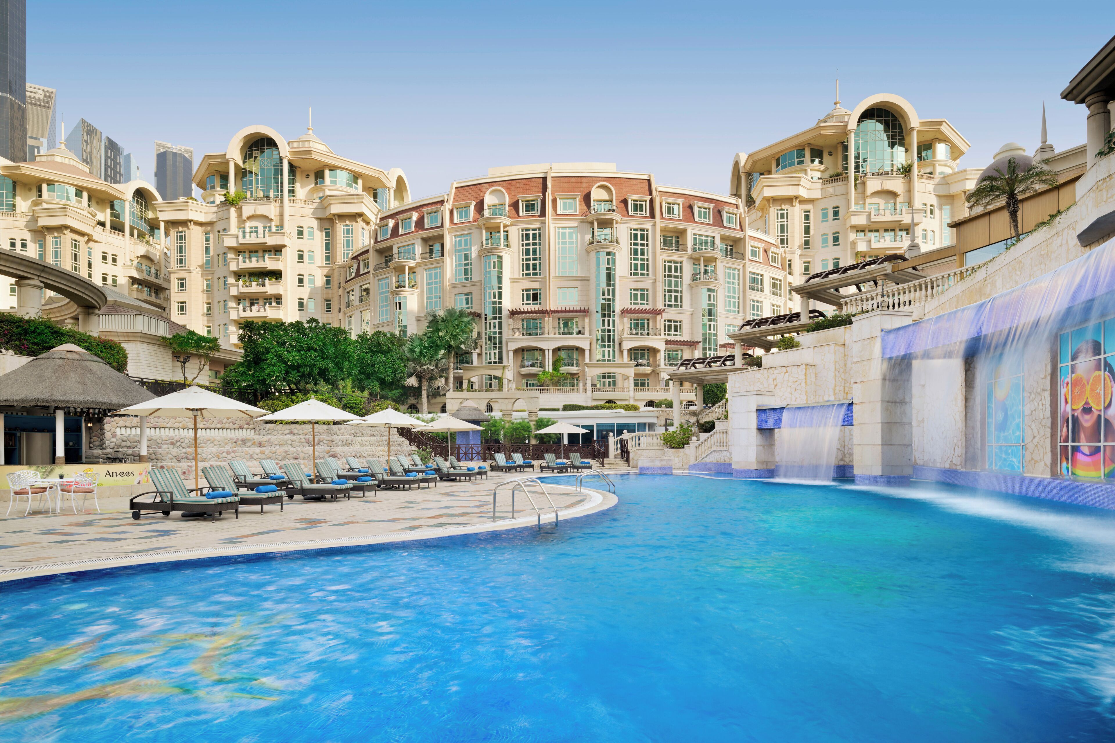 Alberca al aire libre, sombrillas en la alberca y camastros 