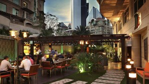 An outdoor dining area with tables and chairs, a covered seating area, and a pathway leading to a building entrance. - Swissôtel Al Murooj Dubai (Dubai)