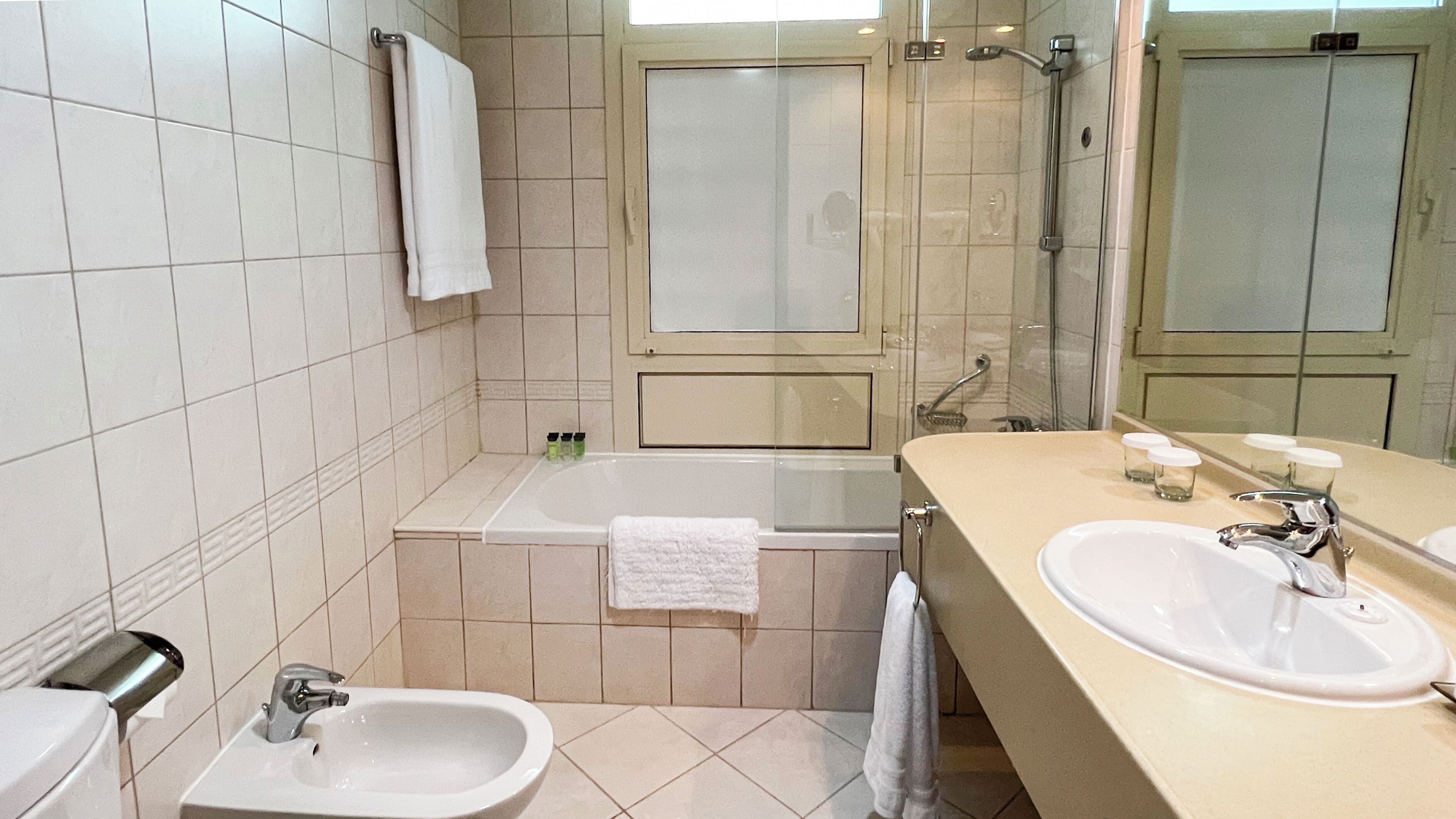 A bathroom with a bathtub, two sinks, a toilet, and a shower.