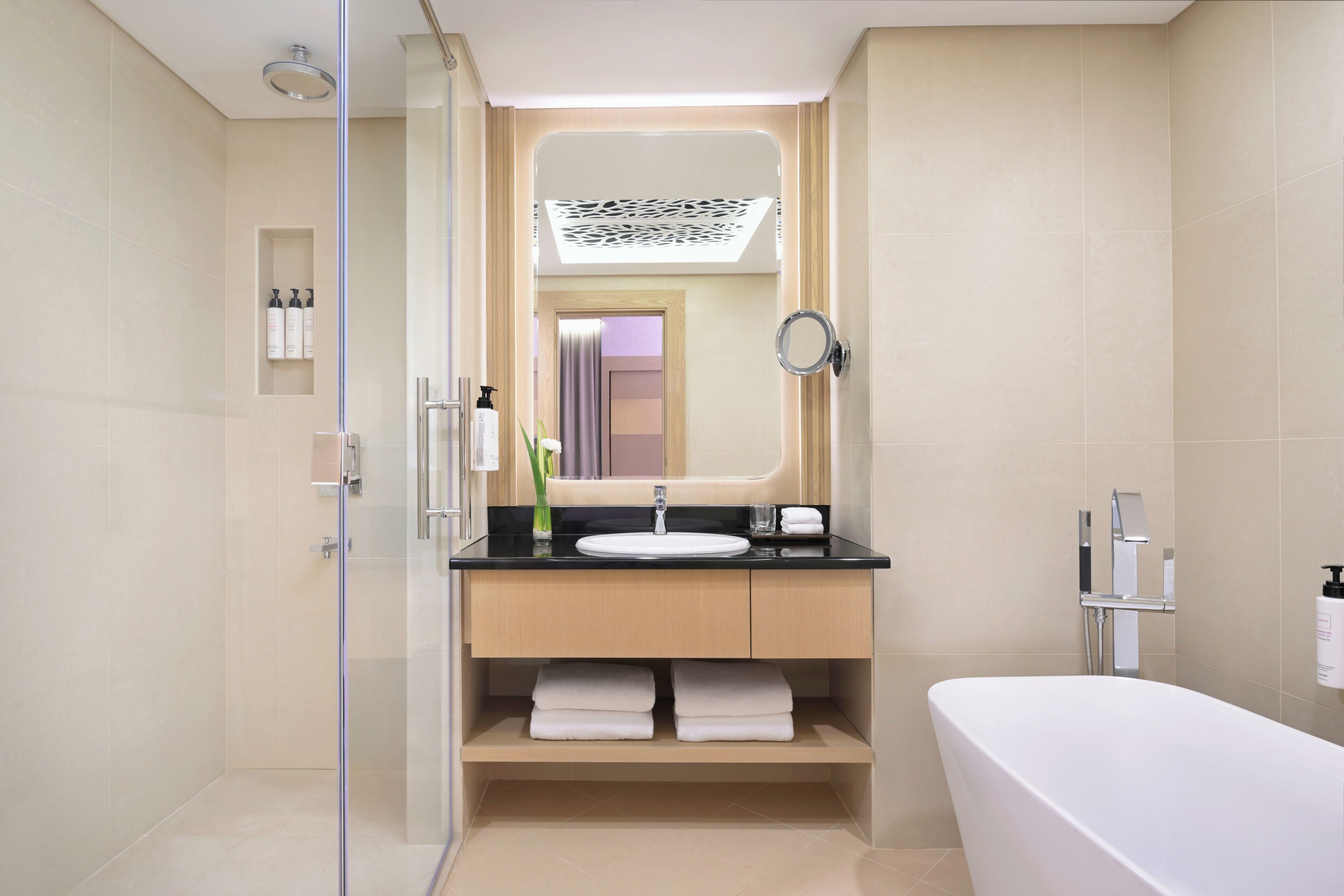 Un bagno moderno con cabina doccia in vetro, lavabo con mobile, vasca da bagno e specchio.