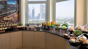 A breakfast buffet with a city view, featuring various food items and a decorative arch. - Swissôtel Al Murooj Dubai (Dubai)
