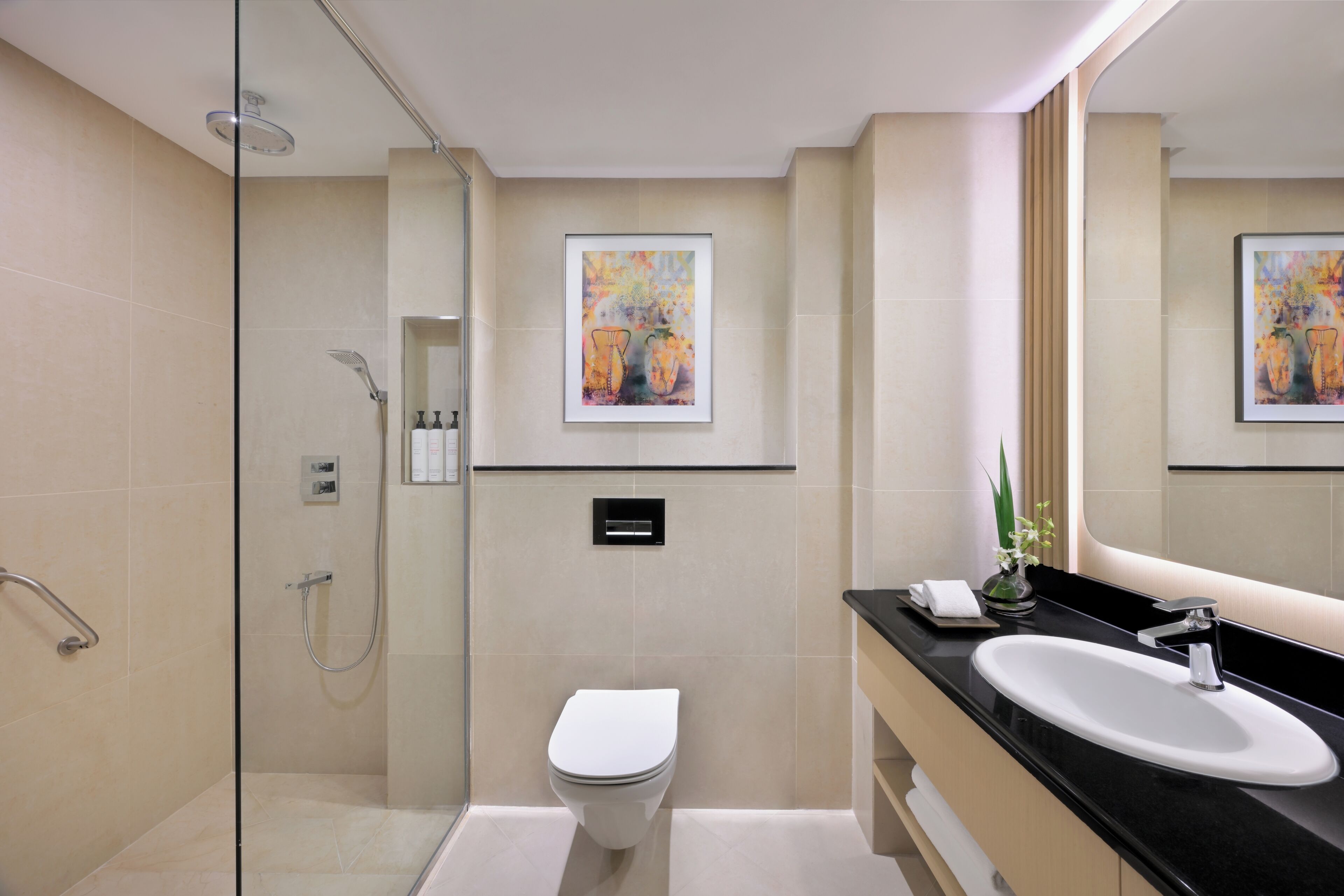 Ein modernes Badezimmer mit einer Duschkabine, einer weißen Toilette und einem schwarzen Waschtisch.