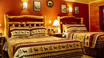 Una habitación acogedora de estilo cabaña con dos camas, cada una con un diseño de colcha único. Hay lámparas de pared y un cartel enmarcado en la pared.