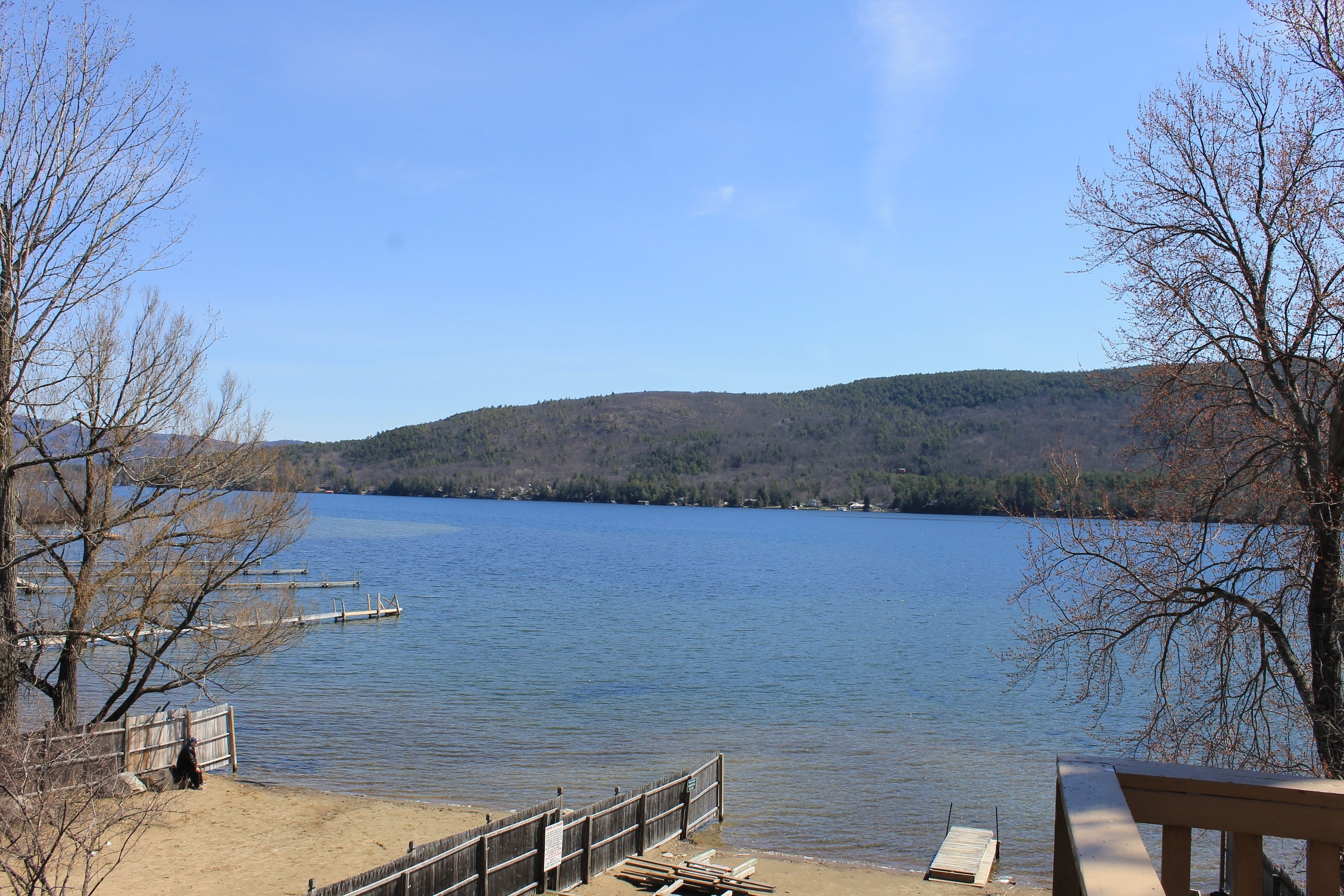 A lakeside view with a wooden dock and a picnic table.
