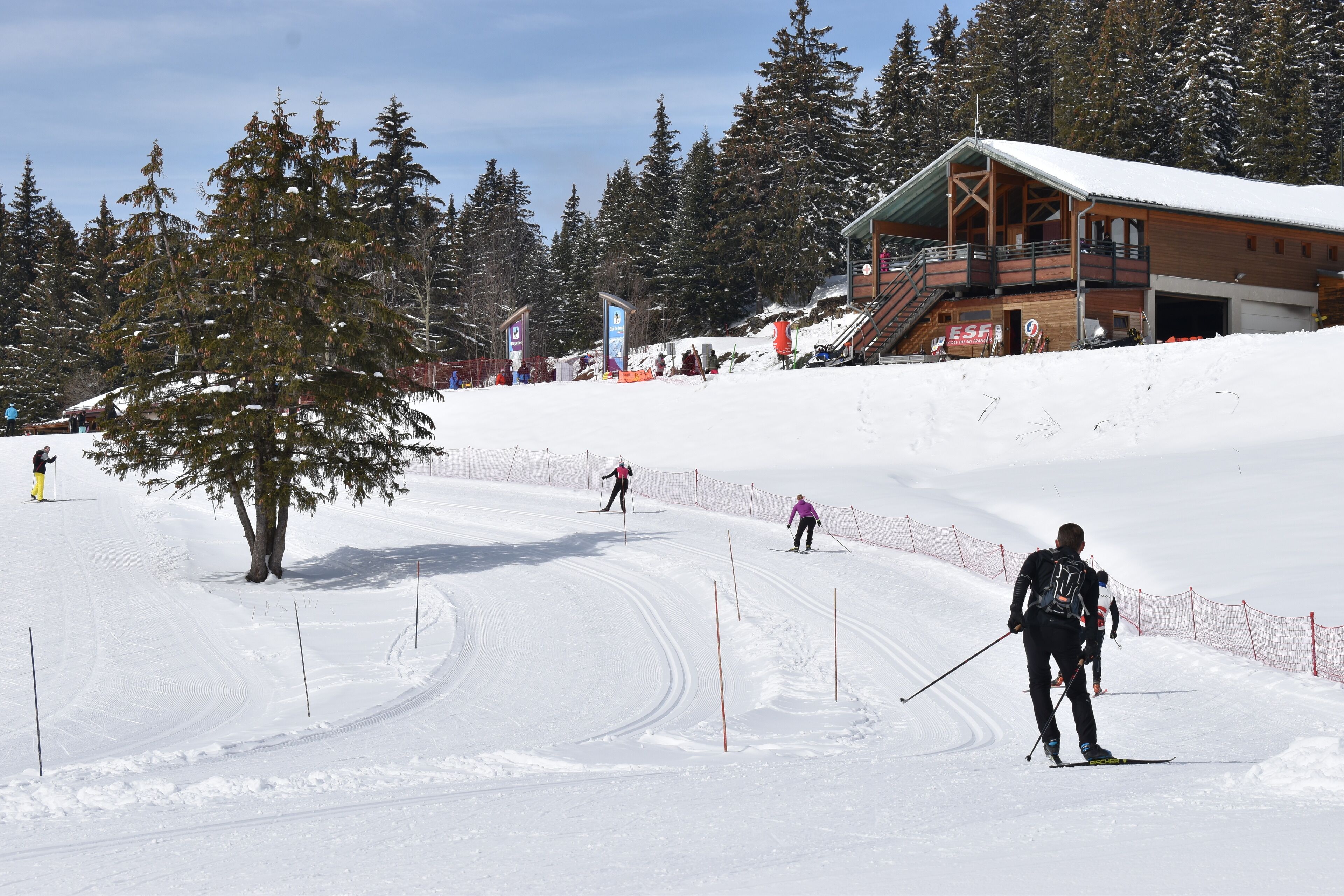 A ski resort with a wooden lodge, ski slopes, and a snow-covered landscape.
