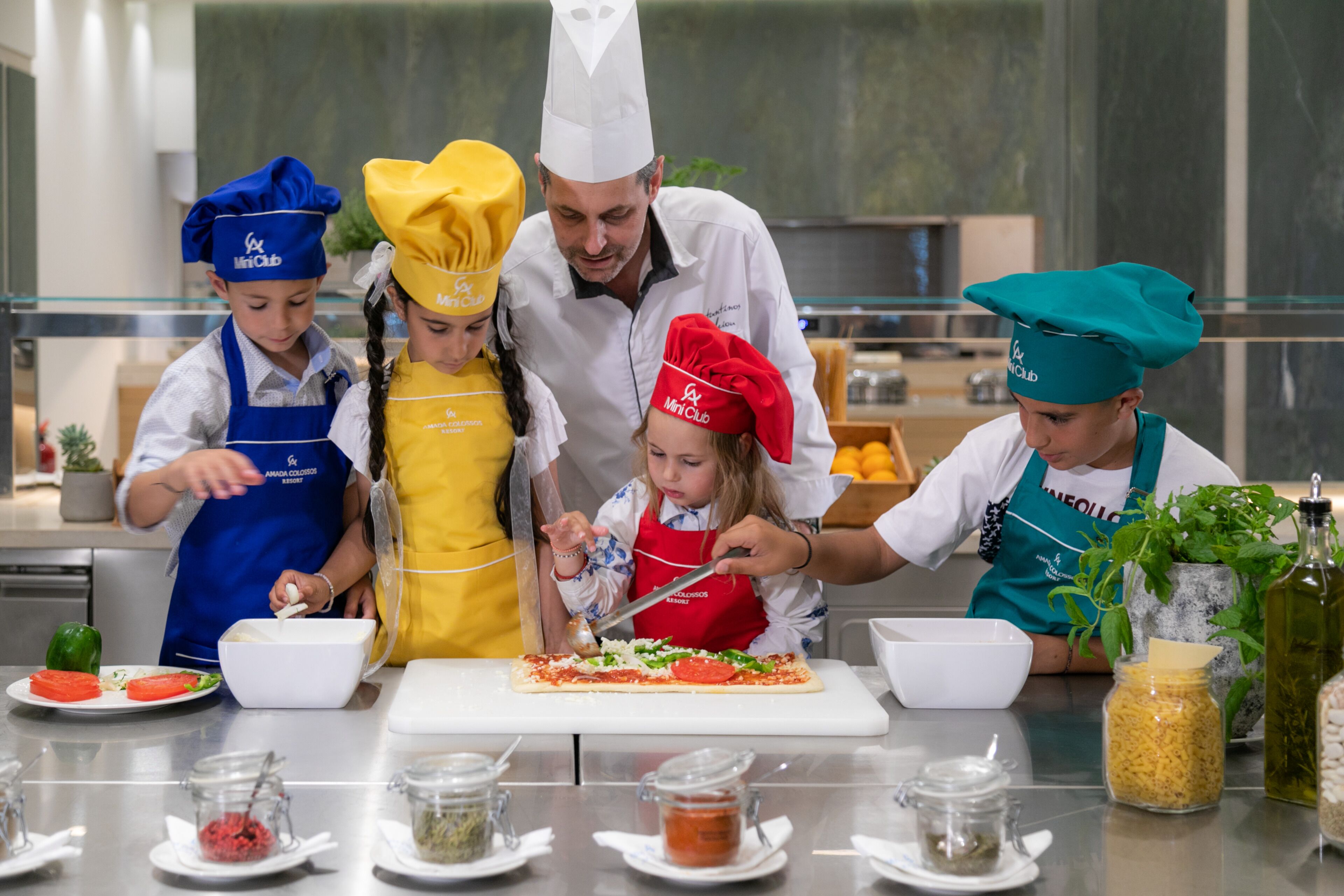 A group of people in chef hats and aprons preparing food in a kitchen.